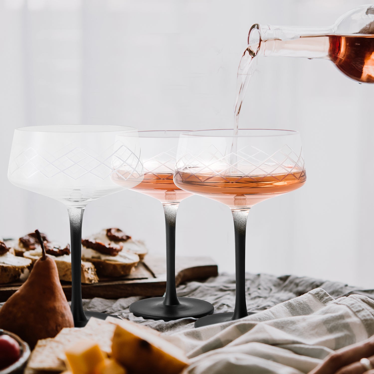 MIAMIO Coupe Cocktail Gläser werden auf dem Esstisch befüllt