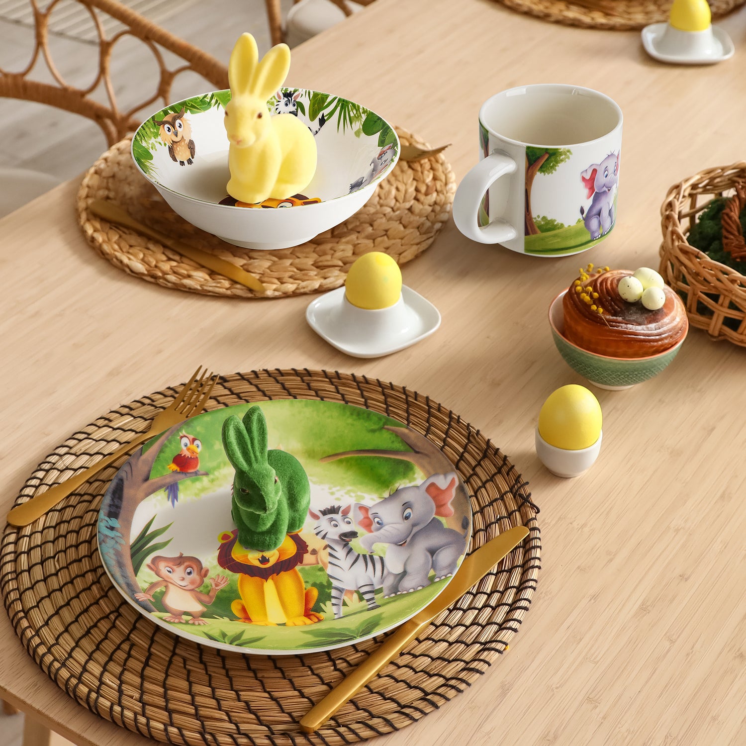 MIAMIO 3er-Set Kindergeschirr mit Jungle Aufdruck auf gedecktem Tisch mit Osterhasen und -Eiern