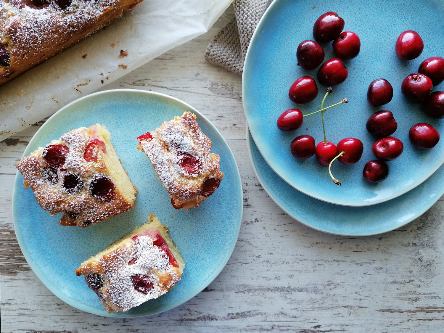 Miamio Lumera Teller mit 3 Stücken Kuchen und Kirschen auf Holztisch