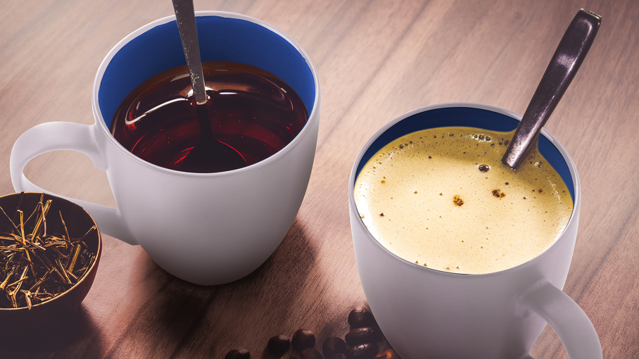 Zwei mit Kaffee und Tee befüllte Tassen von MIAMIO Le Papillon Kollektion mit Löffel